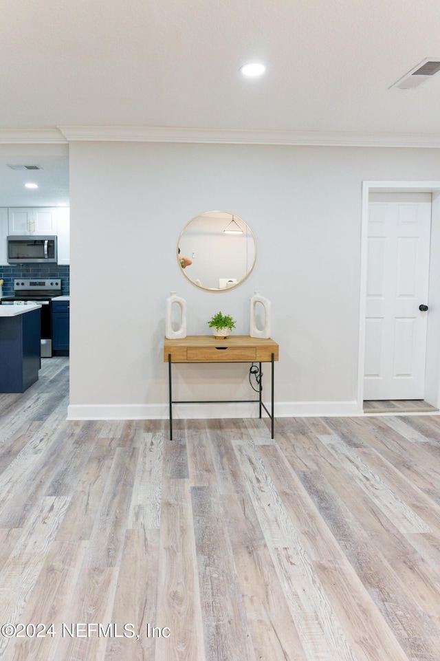 room details with ornamental molding, visible vents, stainless steel appliances, and light wood finished floors
