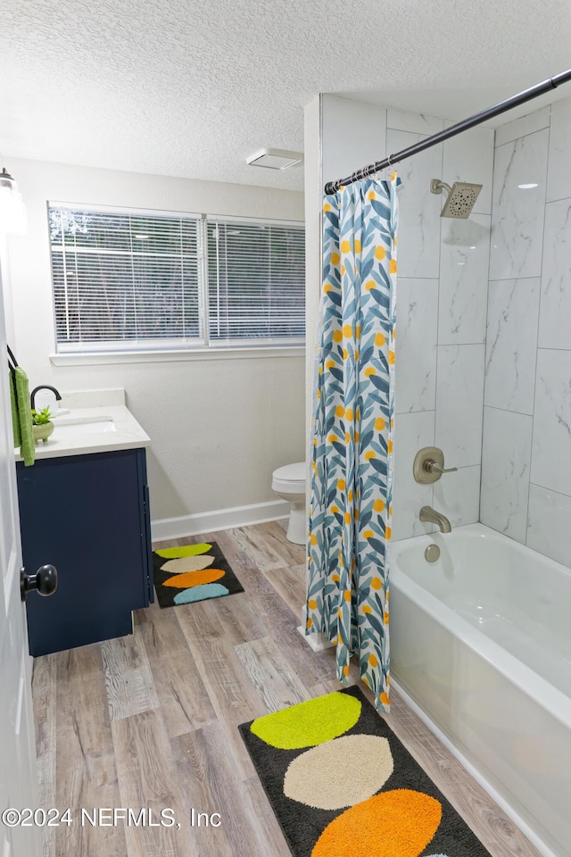 bathroom with toilet, vanity, a textured ceiling, and wood finished floors