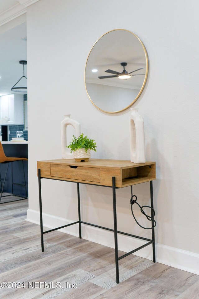 room details featuring decorative backsplash, wood-type flooring, ceiling fan, and ornamental molding