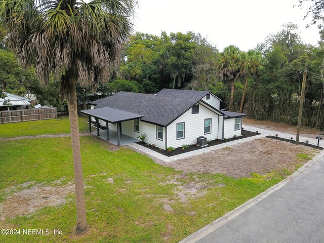 exterior space with a front yard, a carport, and central AC