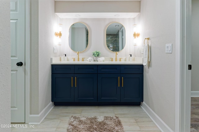 full bath featuring double vanity, baseboards, and a sink
