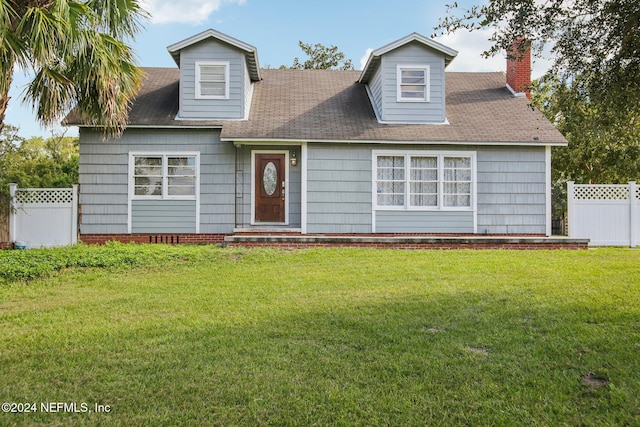 cape cod house featuring a front yard