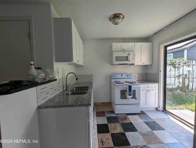 kitchen featuring white appliances, white cabinetry, sink, and dark stone countertops