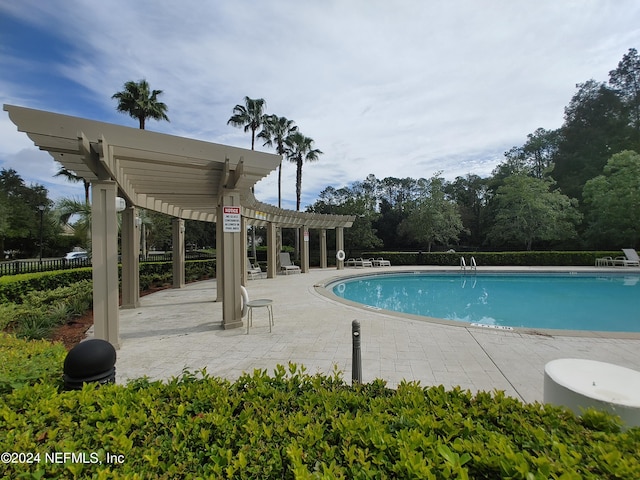 view of swimming pool featuring a patio area and a pergola