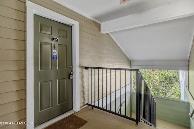 view of exterior entry with a balcony