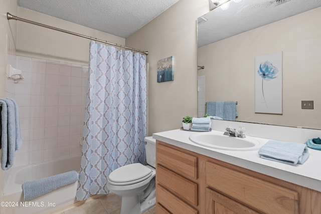 full bathroom with shower / tub combo with curtain, vanity, tile patterned floors, toilet, and a textured ceiling