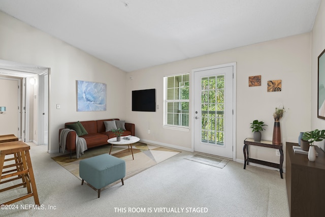 living room featuring lofted ceiling and light colored carpet