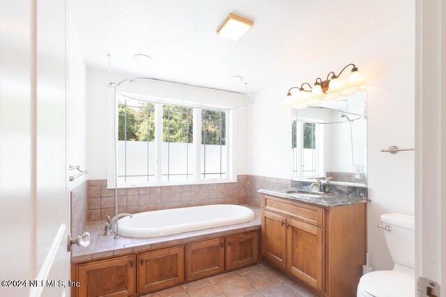 bathroom featuring a bathtub, tile patterned flooring, vanity, and toilet