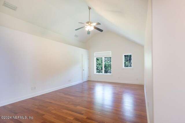 spare room with high vaulted ceiling, ceiling fan, and dark wood-type flooring