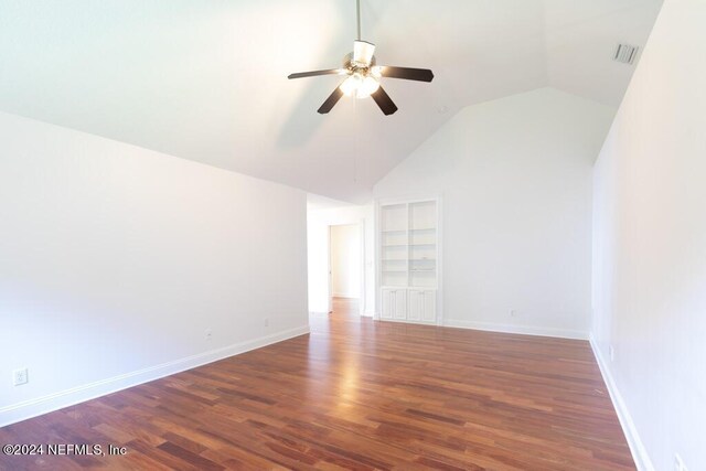 interior space featuring ceiling fan, vaulted ceiling, and dark wood-type flooring