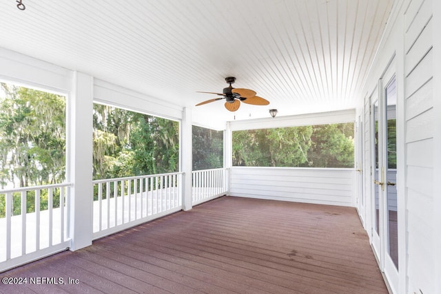 unfurnished sunroom with ceiling fan