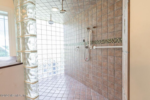 bathroom featuring tile patterned flooring and tiled shower