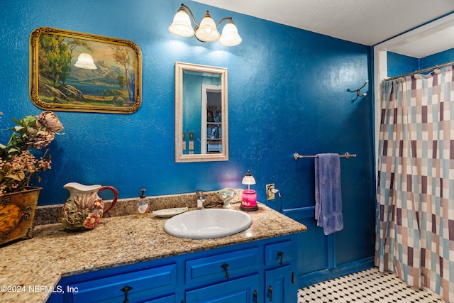 bathroom with a shower with shower curtain, vanity, a textured ceiling, and tile patterned floors