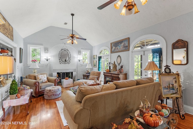 living room featuring wood-type flooring, vaulted ceiling, and ceiling fan