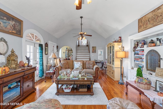 living room with lofted ceiling, ceiling fan, and light hardwood / wood-style flooring