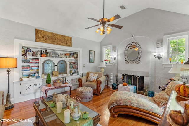 living room featuring a wealth of natural light, lofted ceiling, and light hardwood / wood-style floors