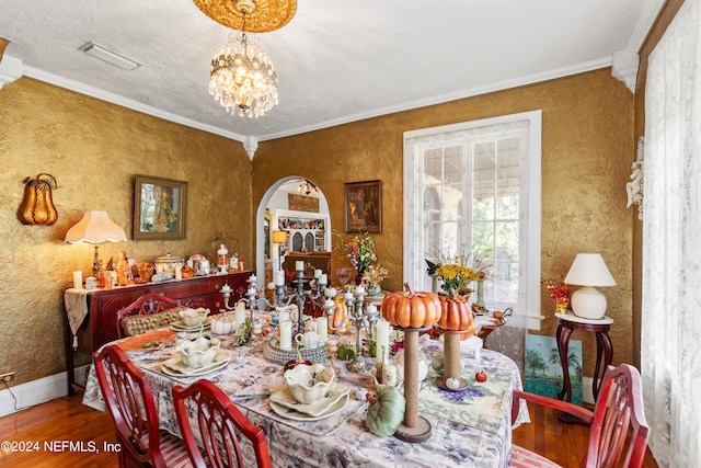 dining room with ornamental molding, hardwood / wood-style floors, and a notable chandelier