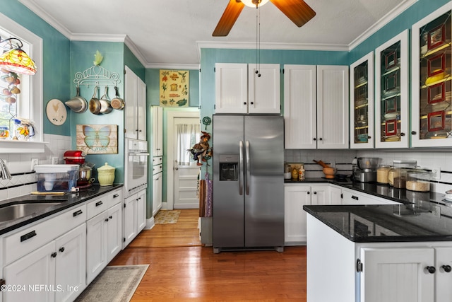 kitchen with white oven, hardwood / wood-style flooring, stainless steel fridge with ice dispenser, white cabinets, and ceiling fan