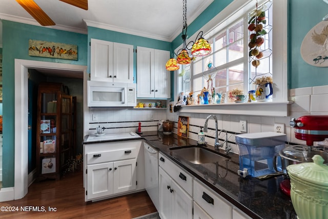 kitchen with hanging light fixtures, sink, white appliances, and white cabinetry