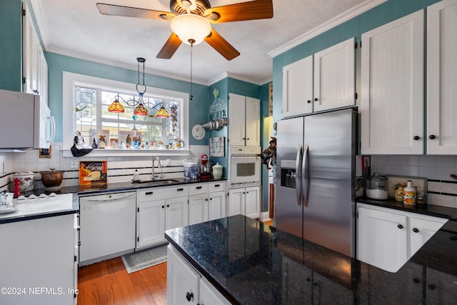 kitchen with white appliances, sink, ceiling fan, and white cabinets