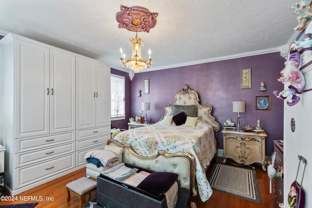 bedroom featuring a notable chandelier, crown molding, and hardwood / wood-style flooring