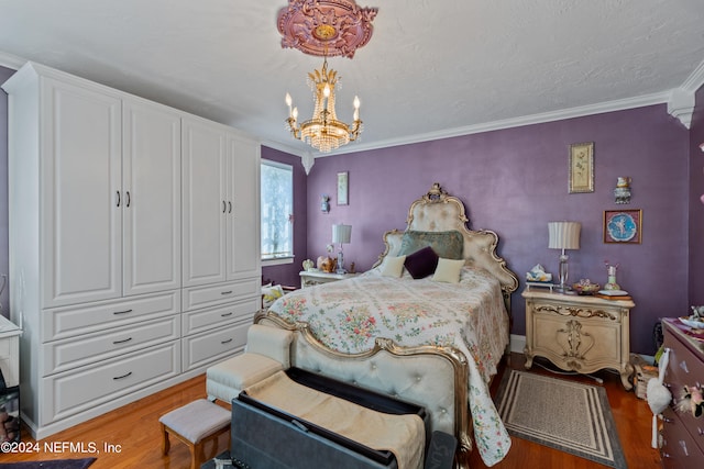 bedroom featuring ornamental molding, an inviting chandelier, and hardwood / wood-style flooring