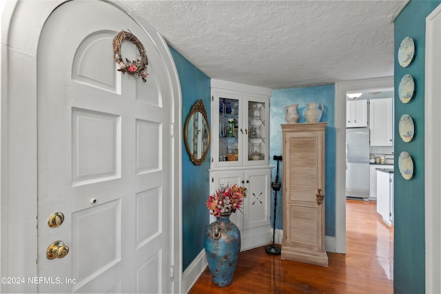 foyer entrance with wood-type flooring and a textured ceiling