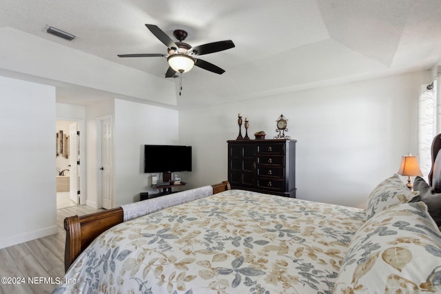 bedroom with ceiling fan, connected bathroom, and light hardwood / wood-style floors