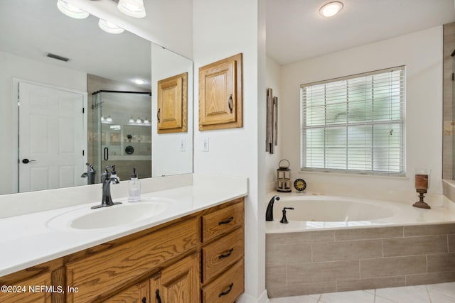 bathroom featuring tile patterned flooring, independent shower and bath, and vanity