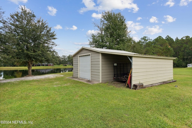 view of outbuilding with a lawn and a water view