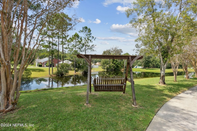 view of home's community featuring a lawn and a water view