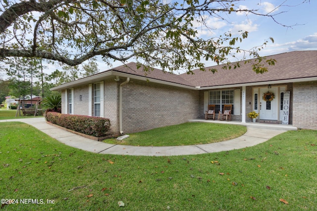 view of side of property with a lawn and covered porch