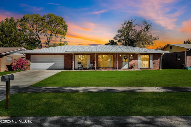 view of front of house featuring a lawn, a porch, concrete driveway, a garage, and brick siding