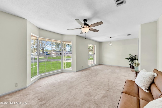 unfurnished living room with a ceiling fan, carpet, and visible vents