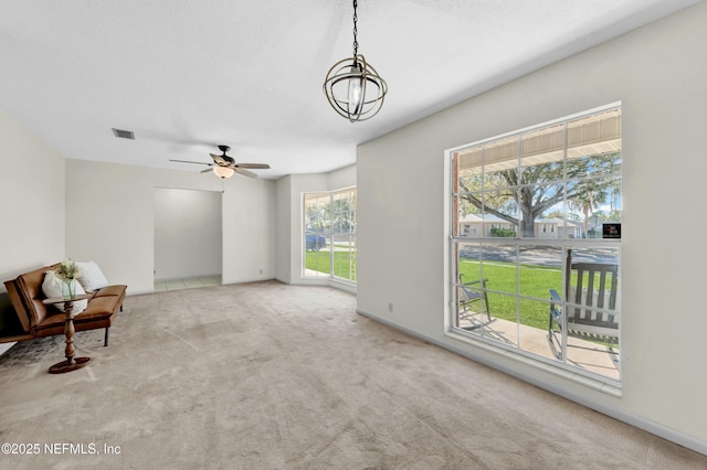 unfurnished room with visible vents, carpet floors, and a ceiling fan