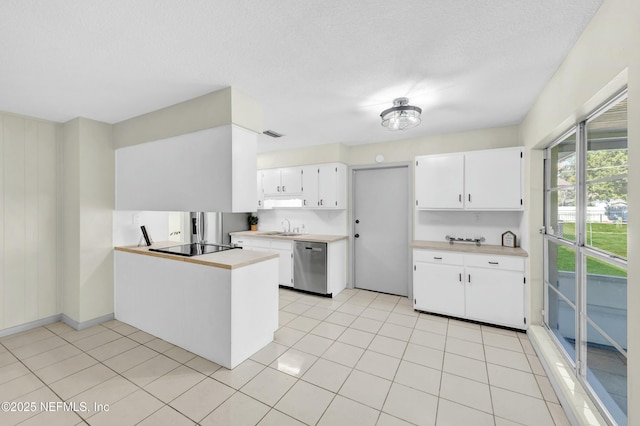 kitchen featuring dishwasher, light countertops, a peninsula, white cabinetry, and a sink