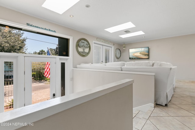 laundry area with a skylight and light tile patterned floors