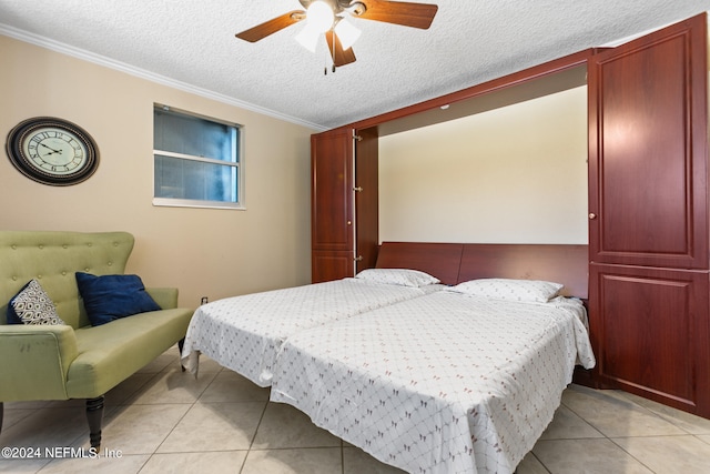 tiled bedroom featuring a textured ceiling, ornamental molding, and ceiling fan