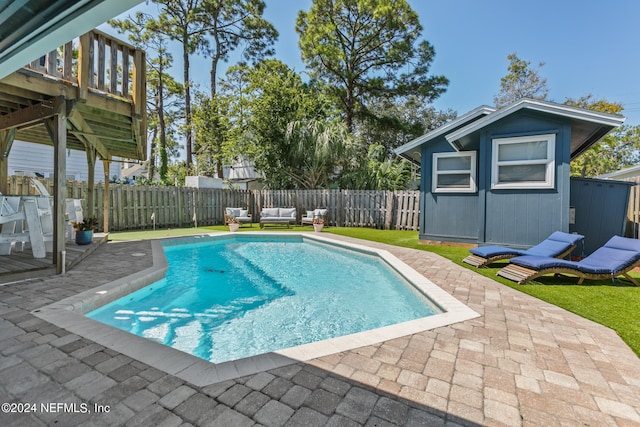 view of swimming pool featuring a patio and a storage unit