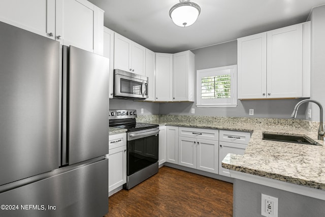 kitchen with appliances with stainless steel finishes, sink, dark hardwood / wood-style flooring, and white cabinetry