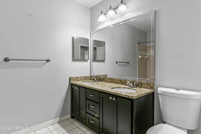 bathroom with walk in shower, vanity, tile patterned flooring, and toilet