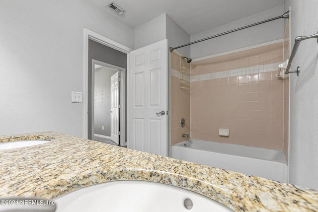 bathroom with vanity and tiled shower / bath combo