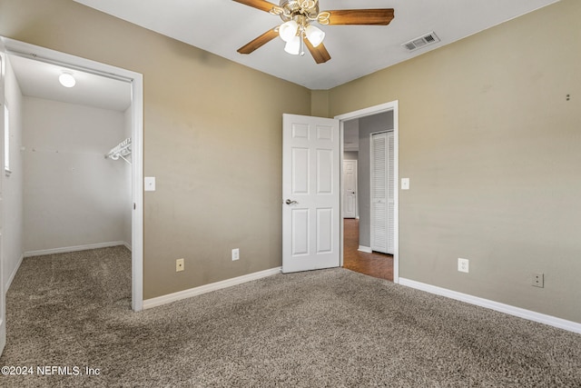 unfurnished bedroom featuring dark colored carpet and ceiling fan