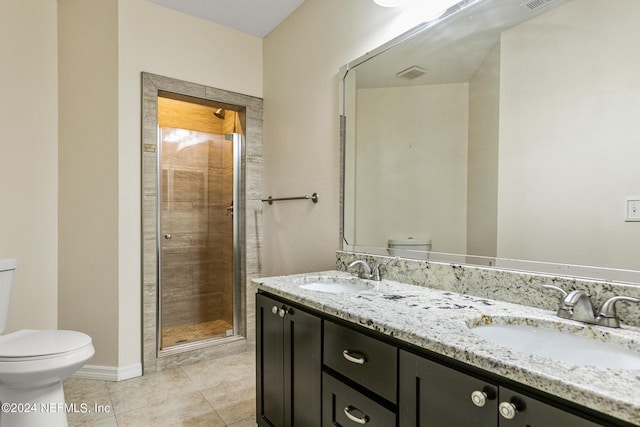 bathroom with tile patterned flooring, walk in shower, vanity, and toilet