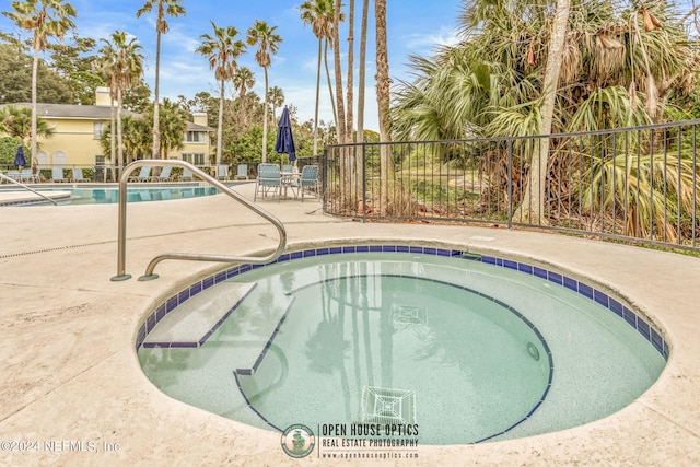 view of swimming pool with a patio and a hot tub