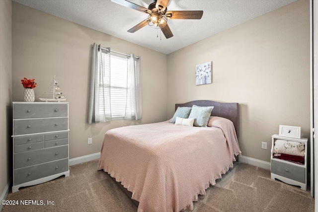 carpeted bedroom featuring ceiling fan and a textured ceiling