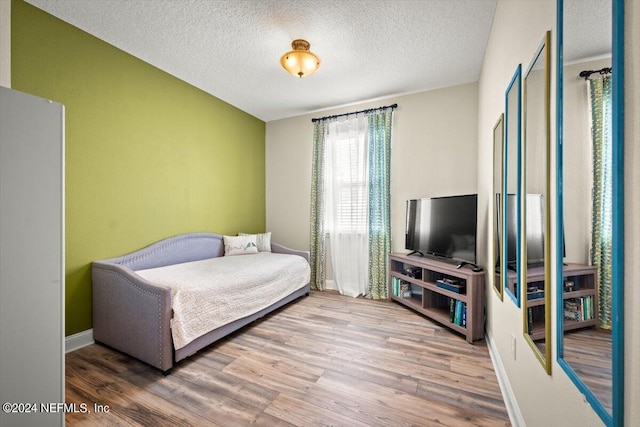 bedroom with hardwood / wood-style flooring and a textured ceiling