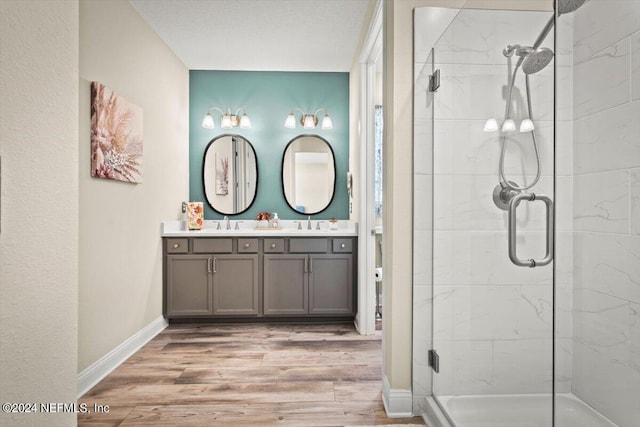 bathroom with hardwood / wood-style floors, vanity, and a shower with door