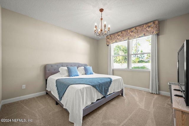 carpeted bedroom with a chandelier and a textured ceiling