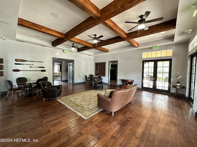 living room featuring french doors, coffered ceiling, a textured ceiling, dark wood-type flooring, and beam ceiling